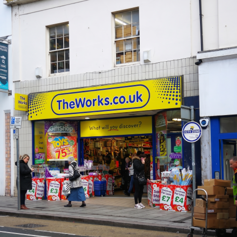 People shopping at TheWorks.co.uk, a gift shop offering toys, games, and festive deals in a UK high street location