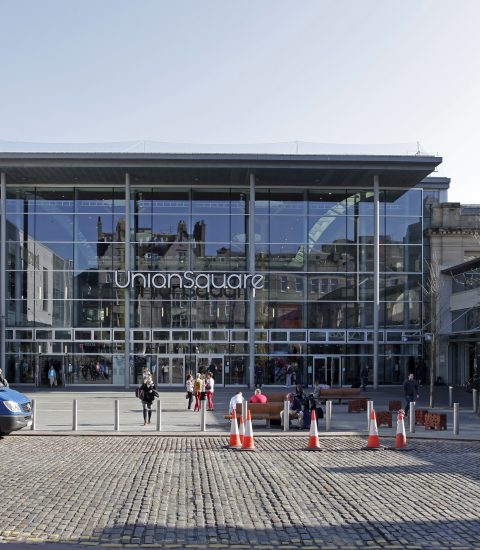 Front view of Union Square shopping centre in Aberdeen with people and traffic cones in foreground