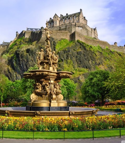 Ross Fountain with Edinburgh Castle in the background, surrounded by vibrant greenery and flowers