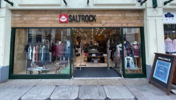 Exterior view of Saltrock clothing store with open doors and display windows on a high street pathway
