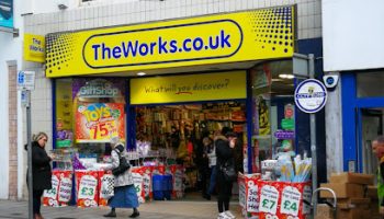Outdoor view of a high street shop with a yellow TheWorks.co.uk sign above the entrance