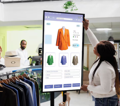 Woman shopping for blazers on a digital screen in a clothing store, selecting options and viewing styles